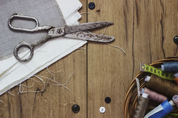 Kit da cucito. Forbici, bobine con filo e aghi sul vecchio sfondo di legno — Foto Stock