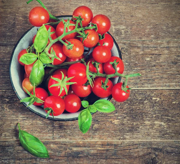 Tomates cereja frescos em uma tigela de metal em um fundo escuro — Fotografia de Stock