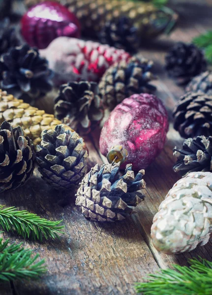 Brinquedos para a árvore de Natal e pinhas no fundo de madeira velha — Fotografia de Stock
