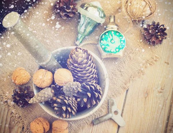Speelgoed voor de kerstboom en dennenappels op oude houten achtergrond — Stockfoto
