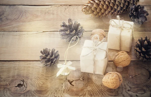 Brinquedos para a árvore de Natal e pinhas no fundo de madeira velha — Fotografia de Stock