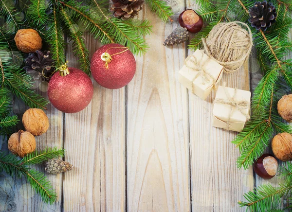 Spielzeug für den Weihnachtsbaum und Tannenzapfen auf altem Holzgrund — Stockfoto