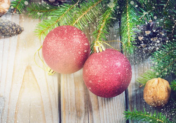 Speelgoed voor de kerstboom en dennenappels op oude houten achtergrond Nieuwjaar — Stockfoto