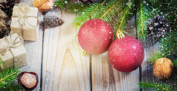 Speelgoed voor de kerstboom en dennenappels op oude houten achtergrond Nieuwjaar — Stockfoto