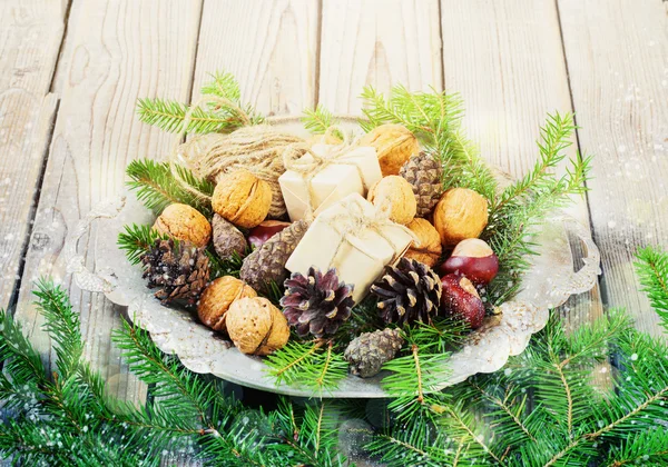Jouets pour le sapin de Noël et cônes de pin dans un bol en métal, sur un vieux fond en bois nouvel an — Photo