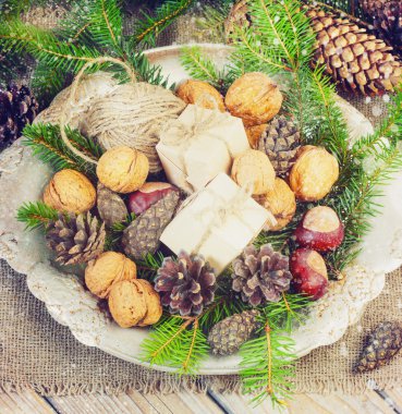 toys for the Christmas   tree and pine cones in a metal bowl, on old wooden background  new Year