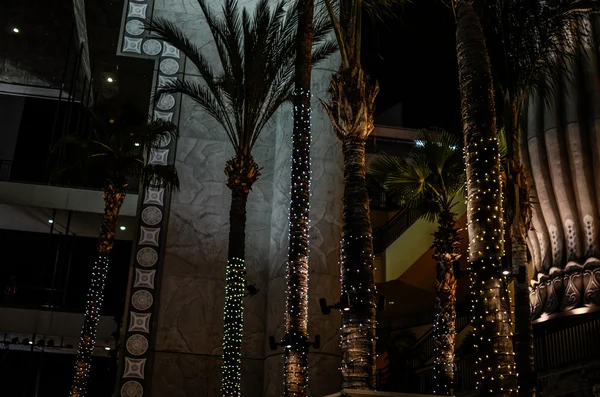 Palm trees and lights at the Hollywood & Highland Center. Hollywood district in Los Angeles, California. — Stock Photo, Image