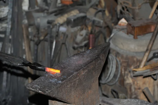 Smid smeedt een gloeiende metalen hamer — Stockfoto