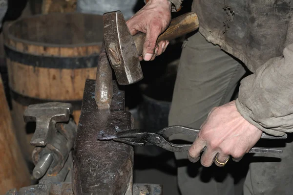 Fabbro forgia un martello di metallo rovente — Foto Stock
