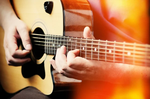 Adam akustik gitar çalıyor. 