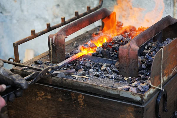 Blacksmith forges a horseshoe — Stock Photo, Image