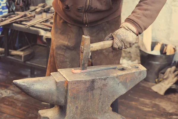 Blacksmith working metal with hammer on the anvil — Stock Photo, Image