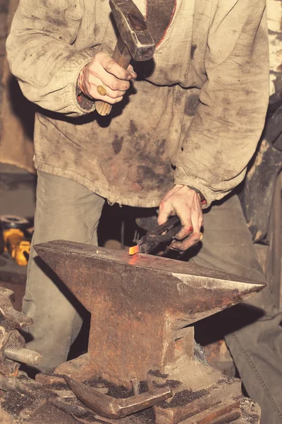 Schmied bearbeitet Metall mit Hammer auf dem Amboss — Stockfoto