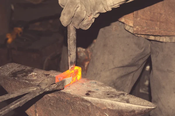 Herrero trabajando metal con martillo en el yunque — Foto de Stock