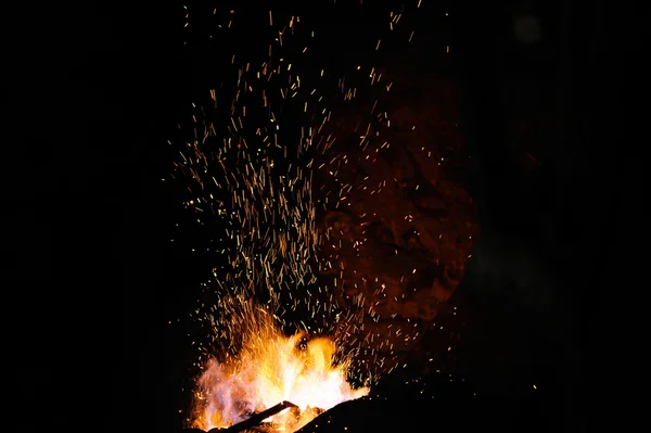 Pontas de chama de fogo de ferreiro com faíscas no fundo escuro — Fotografia de Stock