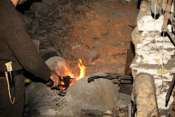 Ferreiro que trabalha na forja processa o metal  . — Fotografia de Stock