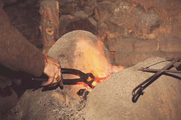 Blacksmith working in the forge processes the metal . — Stock Photo, Image