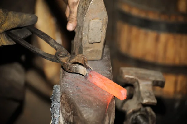 Blacksmith working in the forge processes the metal . — Stock Photo, Image