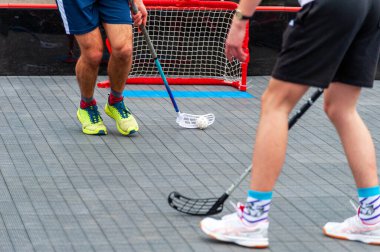 Top ve sopayla koşan florbol oyuncusu. Yer hokeyi konsepti.