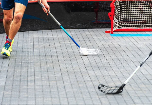 Top ve sopayla koşan florbol oyuncusu. Yer hokeyi konsepti.