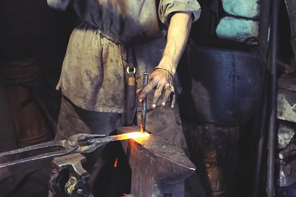 Кузнец работает на металле на наковальне на высокой скорости кузницы — стоковое фото