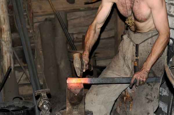 Herrero trabajando en metal sobre yunque a gran velocidad — Foto de Stock