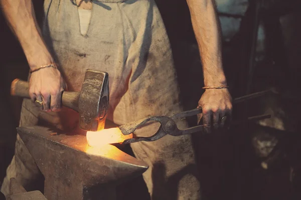 Кузнец обрабатывающий металл с молотком — стоковое фото