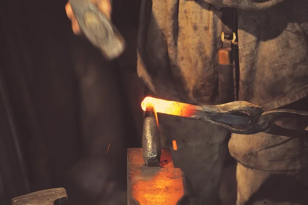 Ferreiro trabalhando metal com martelo — Fotografia de Stock