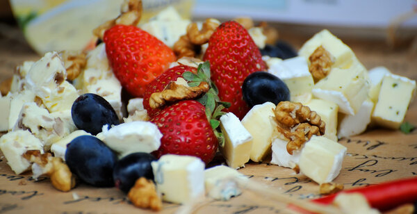 Cheese plate with grapes, nuts and strawberry