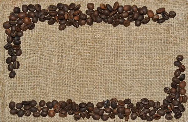 Spilled coffee beans frame over burlap textile — Stock Photo, Image