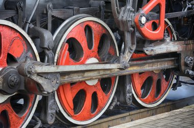 Eski bir buharlı lokomotif ve sürücü mekanizması ve kırmızı tekerlekli tren