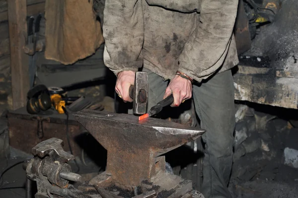 ハンマーのアンビルに熱い鉄を鍛造の詳細ショット — ストック写真