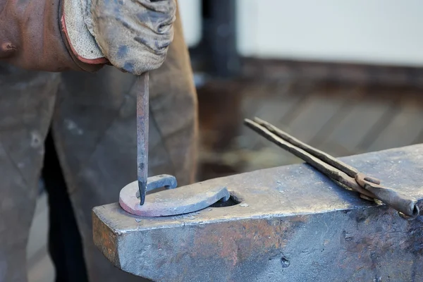 Smid smeedt een hoefijzer — Stockfoto