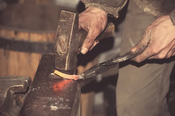 Smid smeedt een gloeiende metalen hamer — Stockfoto