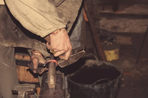 Blacksmith forges a red-hot metal hammer — Stock Photo, Image