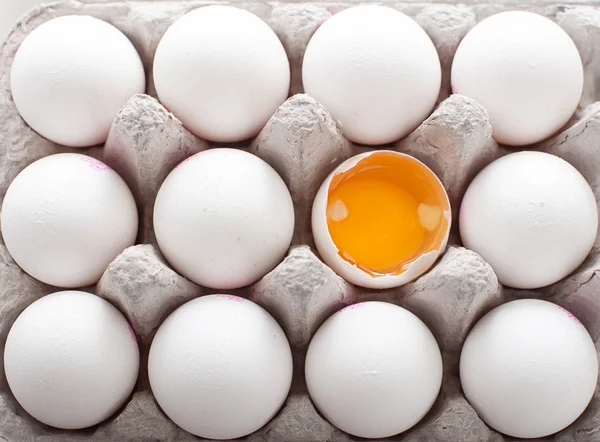 Tucet vajec v kartonu ukazující žloutku — Stock fotografie