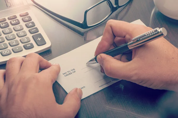 Mann schreibt einen Zahlungsscheck — Stockfoto