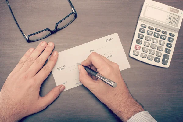 Mann schreibt einen Scheck — Stockfoto