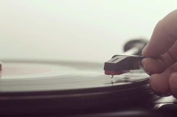 Bir vinil kayıt turntable koyarak adam