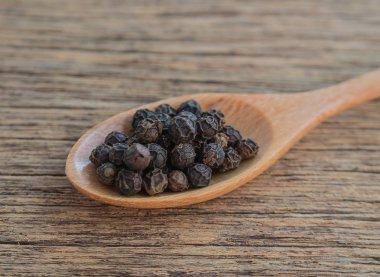 Biber, kara biber, tahta kaşık, ahşap zemin.