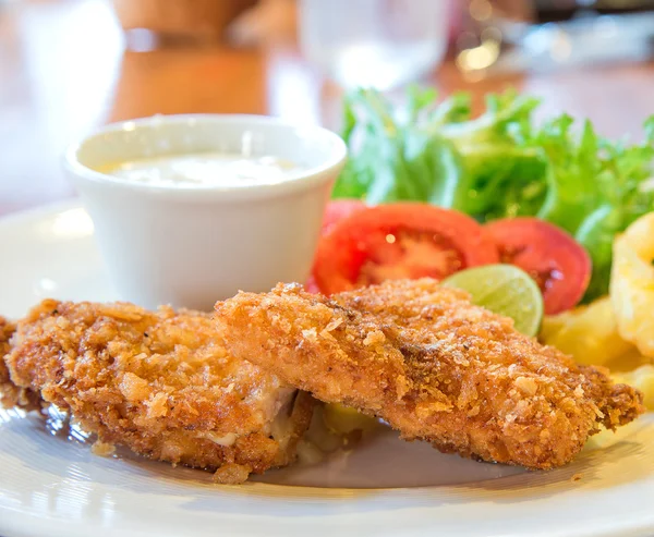 Nuggets de frango, batatas fritas, legumes na mesa de madeira . — Fotografia de Stock