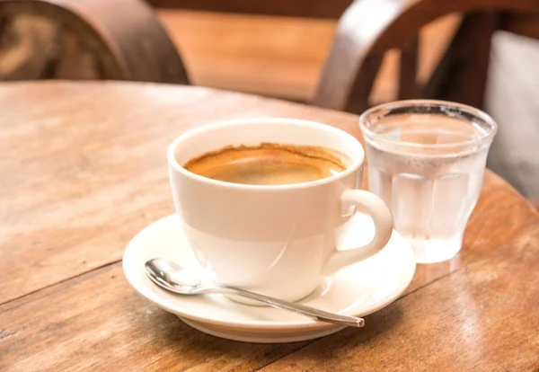 Kawa, białe kawy kubek, szkło woda, drewniany stół. — Zdjęcie stockowe