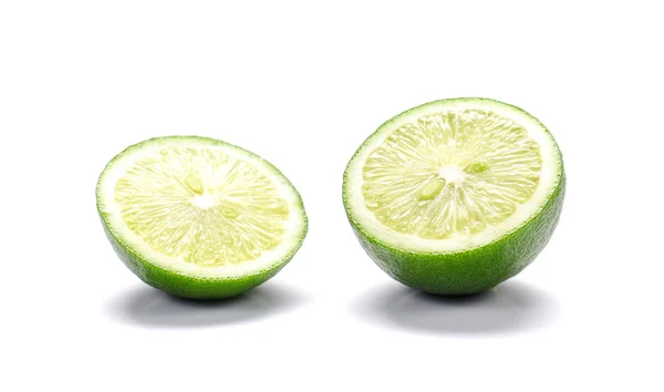 Πράσινα λεμόνια, λεμόνια κομμένα κομμάτια σε άσπρο φόντο. — Φωτογραφία Αρχείου