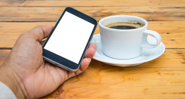 Beyaz ekran telefon elinde akıllı, kahve fincanı ahşap flo üzerinde beyaz