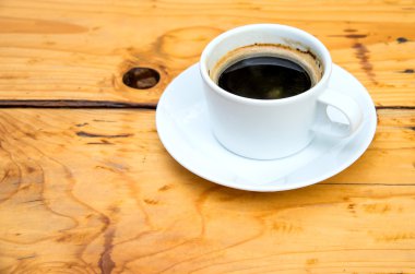 Ahşap zemin üzerinde beyaz kahve fincanı.