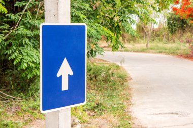 Mavi oklarla işaret, ağaç ve yol arka plan bulanıklık.