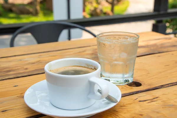 Tazza di caffè bianco, Acqua di vetro sul pavimento in legno . — Foto Stock