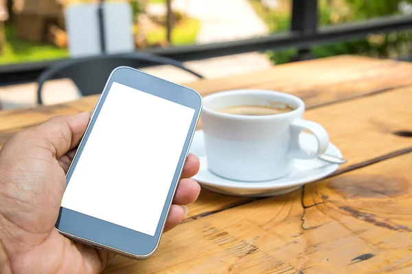 Svart skärm smart telefon i handen, vit kaffekopp på trä flo — Stockfoto