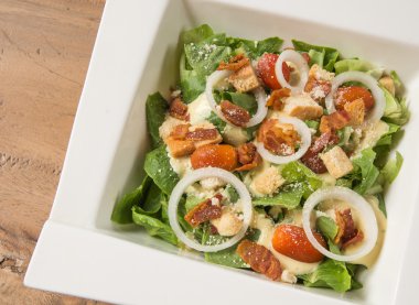 Sezar salatası beyaz plaka, portakal suyu, su woode üzerinde