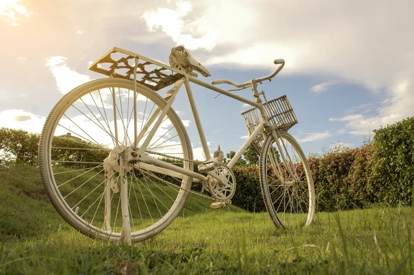 Bicicleta branca no céu de fundo do gramado e nuvens brancas . — Fotografia de Stock